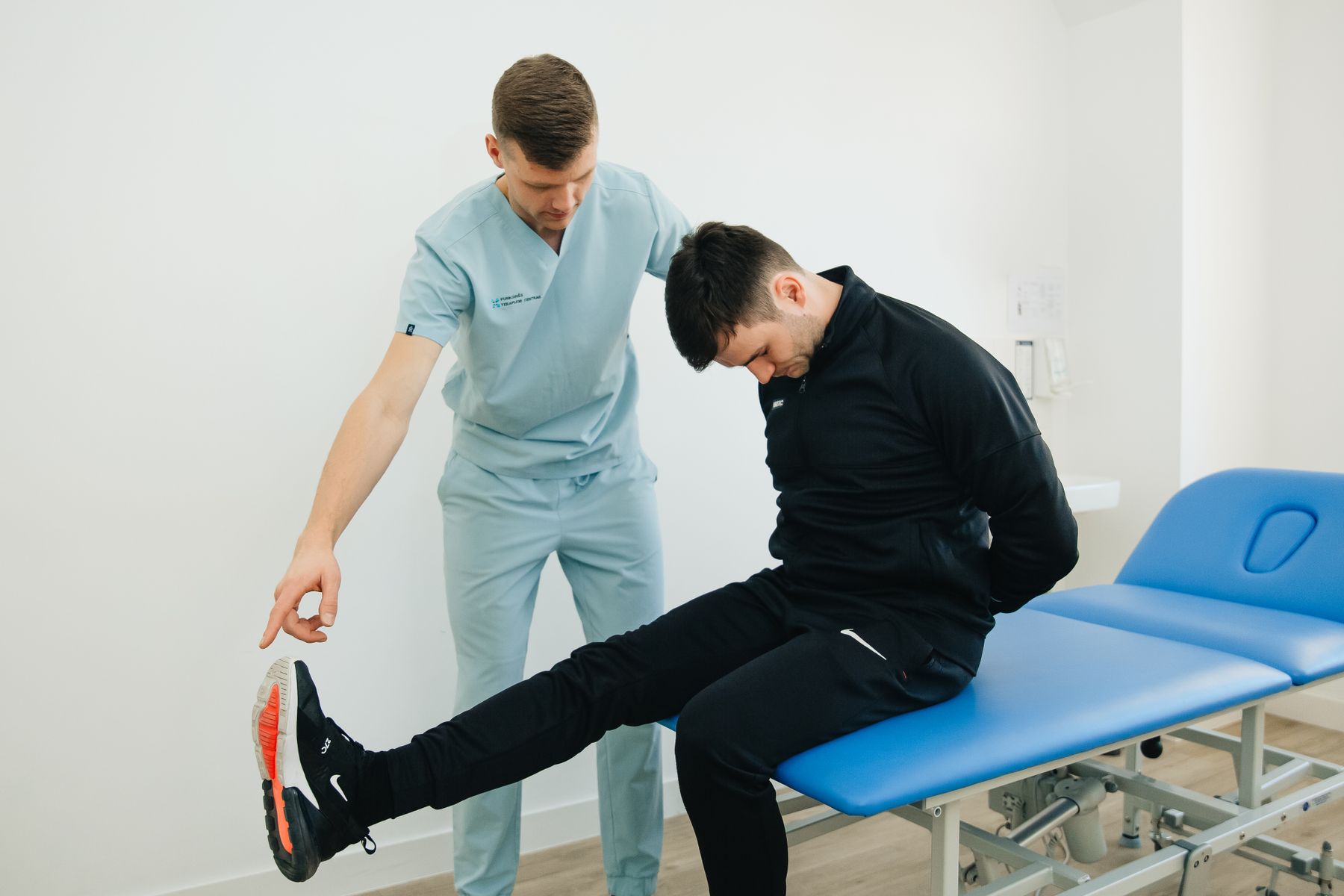 Physiotherapist guiding a patient through a leg stretch